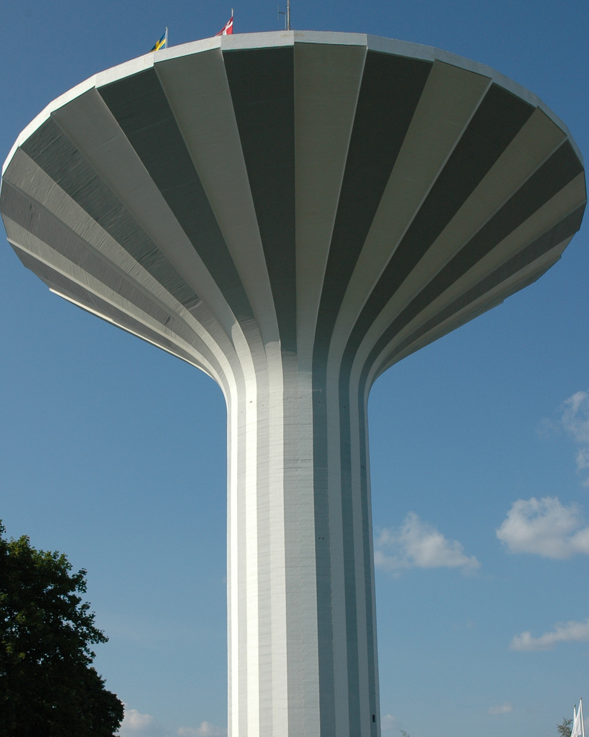 Bild på vattentornet Svampen. Vattentornet har vita och gråa upprättstående ränder som skapar ett mönster - varannan vit, varannan grå. 
